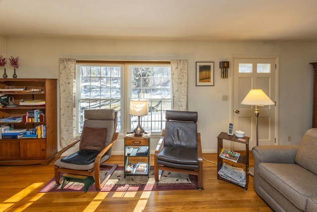 living area with baseboards and wood finished floors