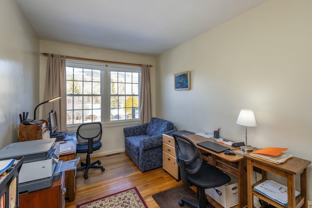 office featuring visible vents, light wood-style flooring, and baseboards