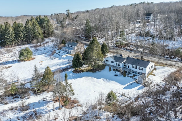 snowy aerial view featuring a forest view