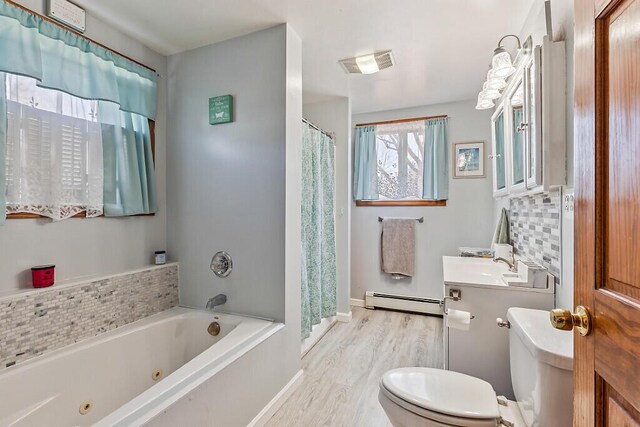 full bath featuring toilet, backsplash, a jetted tub, visible vents, and baseboard heating