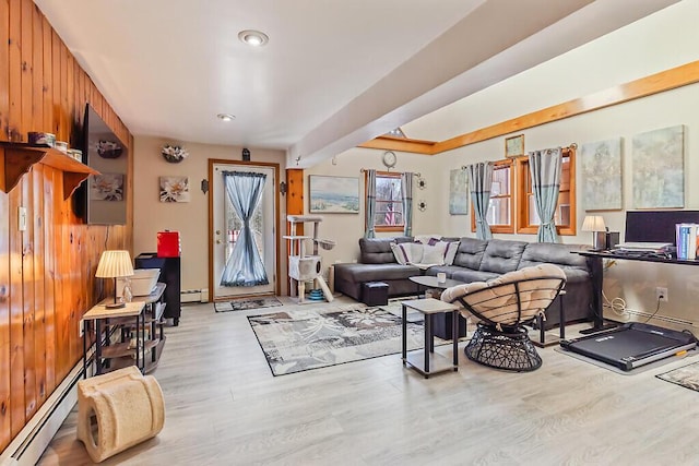 living room with wood finished floors, baseboard heating, and wood walls