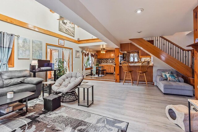 living room featuring stairs, light wood-style flooring, and recessed lighting