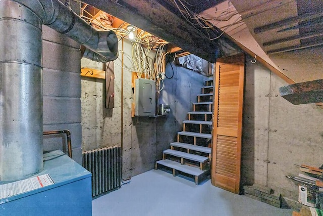 unfinished below grade area with stairs, electric panel, and radiator