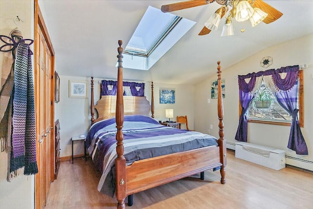 bedroom with lofted ceiling with skylight and wood finished floors