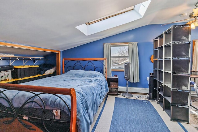 carpeted bedroom featuring baseboards, lofted ceiling with skylight, and a baseboard radiator