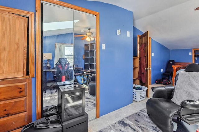 interior space featuring concrete flooring, lofted ceiling, and ceiling fan