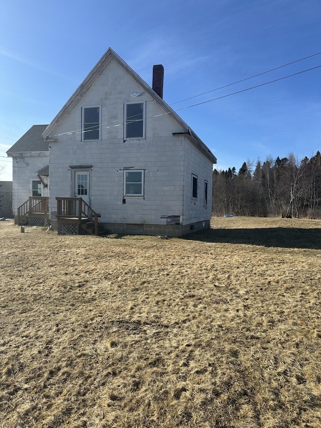 rear view of property featuring a chimney