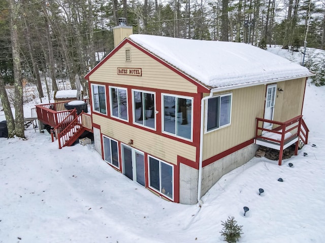 view of snowy exterior featuring a chimney