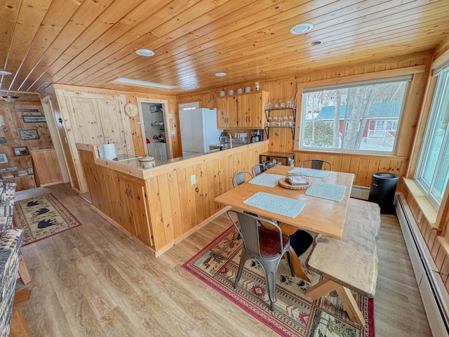 dining room featuring wood ceiling, light wood-style floors, and a baseboard radiator