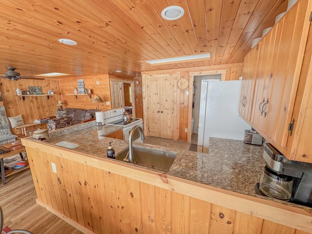 kitchen featuring white appliances, wood finished floors, a skylight, a sink, and wooden ceiling