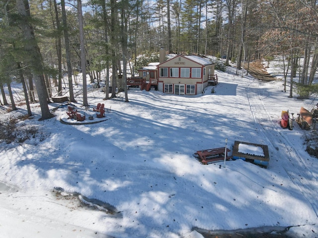 yard layered in snow featuring a deck and a fire pit