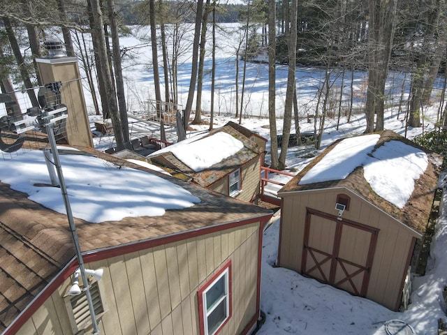 yard covered in snow with a storage unit and an outdoor structure