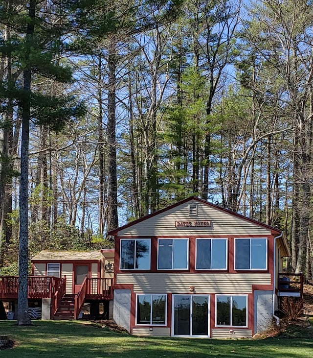 rear view of house with a yard and a deck