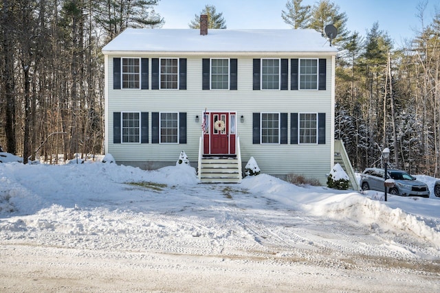 colonial house with entry steps and a chimney