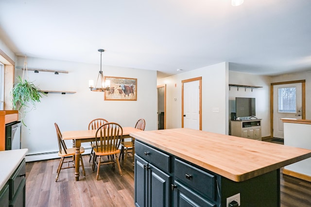 kitchen with wooden counters, a center island, dark wood finished floors, a chandelier, and baseboard heating