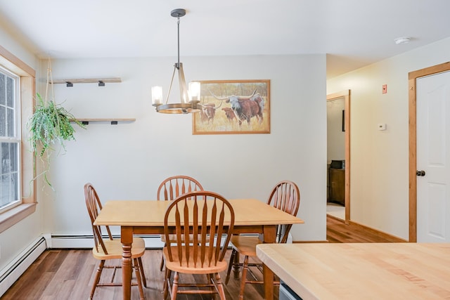 dining room with a chandelier, wood finished floors, and a baseboard radiator