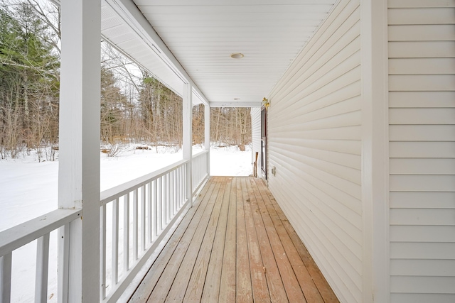 snow covered deck featuring a porch