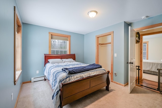 bedroom featuring a baseboard heating unit, light colored carpet, and baseboards