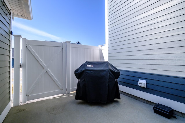 view of patio featuring grilling area, fence, and a gate