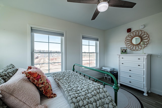 bedroom with a ceiling fan, baseboards, and wood finished floors