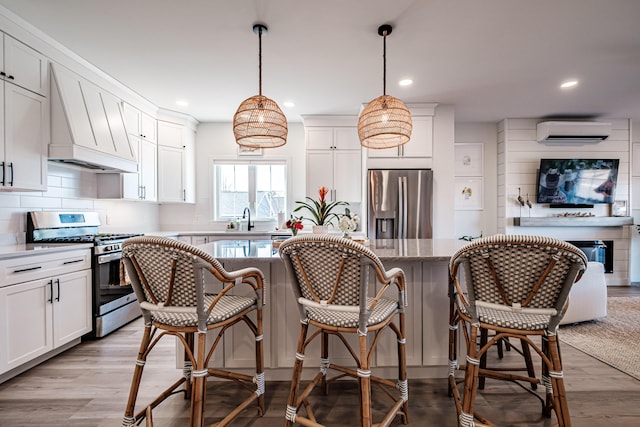 kitchen featuring backsplash, custom exhaust hood, stainless steel appliances, a wall mounted AC, and a sink