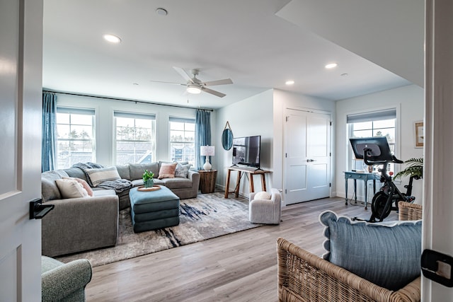 living room featuring baseboards, recessed lighting, a ceiling fan, and light wood-style floors