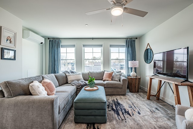 living area with baseboards, a wall mounted air conditioner, ceiling fan, and wood finished floors