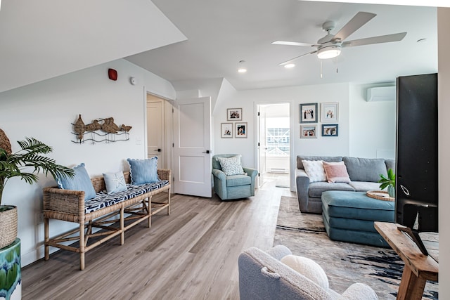 living area with recessed lighting, a wall mounted air conditioner, light wood-style floors, and ceiling fan