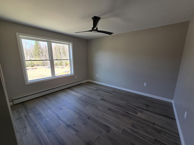 unfurnished room featuring a baseboard heating unit, dark wood finished floors, baseboards, and ceiling fan