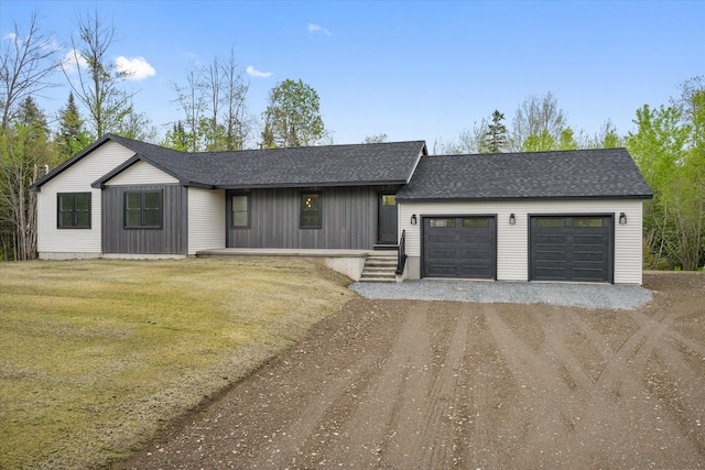 67 Stacey Ln, Kenduskeag, ME 04450 - view of front of house featuring dirt driveway, a shingled roof, an attached garage, and a front lawn