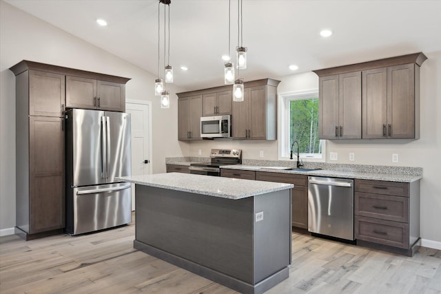 67 Stacey Ln, Kenduskeag, ME 04450 - kitchen featuring appliances with stainless steel finishes, a sink, light wood-style flooring, light stone counters, and vaulted ceiling