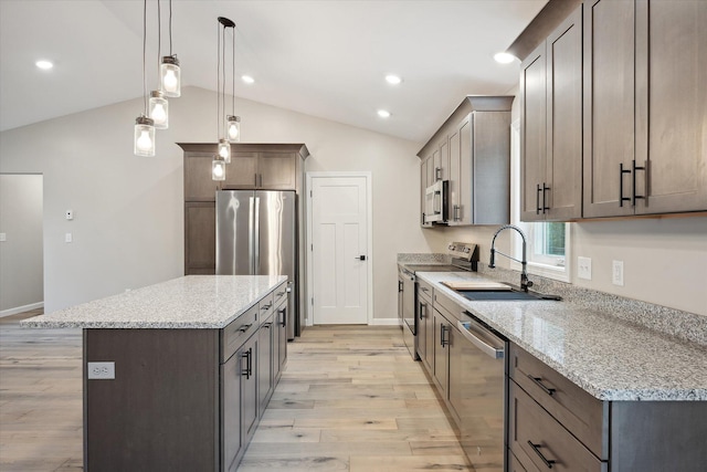 67 Stacey Ln, Kenduskeag, ME 04450 - kitchen featuring appliances with stainless steel finishes, a sink, a kitchen island, lofted ceiling, and light wood-style flooring