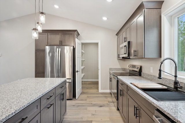 67 Stacey Ln, Kenduskeag, ME 04450 - kitchen with stainless steel appliances, a sink, vaulted ceiling, light wood-style flooring, and pendant lighting