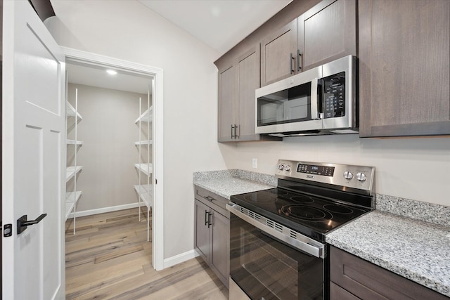 67 Stacey Ln, Kenduskeag, ME 04450 - kitchen with appliances with stainless steel finishes, light wood finished floors, dark brown cabinetry, light stone counters, and baseboards