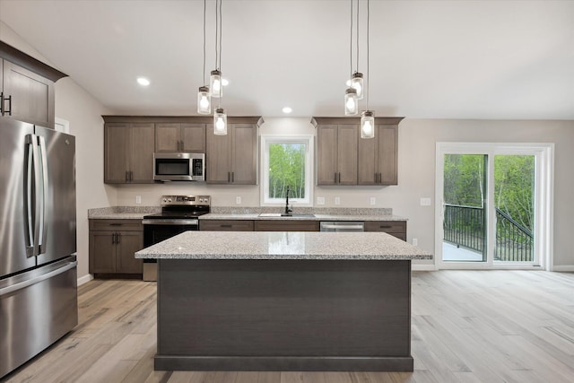 67 Stacey Ln, Kenduskeag, ME 04450 - kitchen featuring stainless steel appliances, light wood finished floors, a kitchen island, light stone counters, and hanging light fixtures