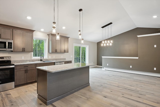 67 Stacey Ln, Kenduskeag, ME 04450 - kitchen with stainless steel appliances, a sink, vaulted ceiling, a baseboard heating unit, and a center island