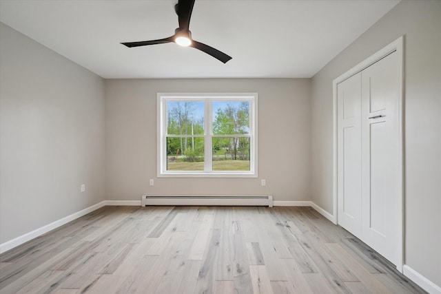 67 Stacey Ln, Kenduskeag, ME 04450 - unfurnished bedroom featuring baseboard heating, light wood finished floors, baseboards, and a ceiling fan