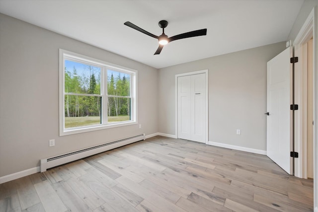67 Stacey Ln, Kenduskeag, ME 04450 - unfurnished bedroom featuring baseboard heating, light wood finished floors, baseboards, and ceiling fan