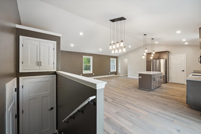 67 Stacey Ln, Kenduskeag, ME 04450 - kitchen with freestanding refrigerator, lofted ceiling, a center island, light wood-style flooring, and decorative light fixtures