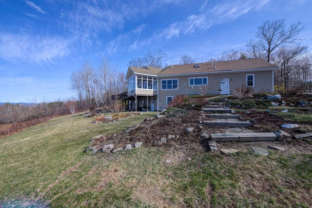 back of property featuring a lawn and a wooden deck