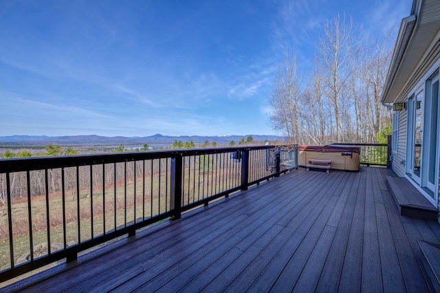 deck with a mountain view and a hot tub