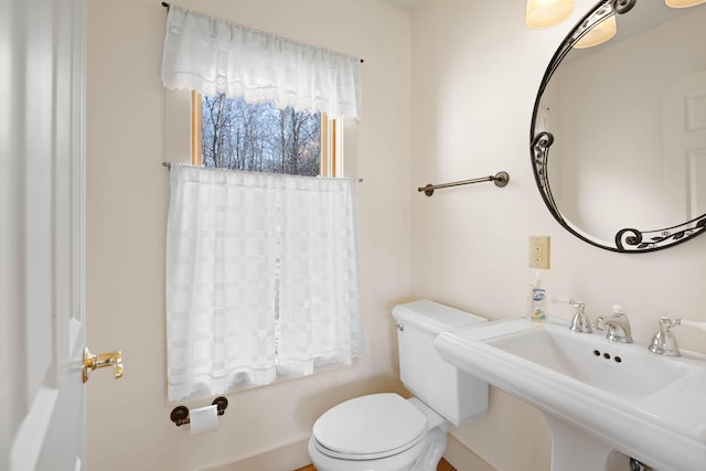 bathroom with a sink, toilet, and a tub to relax in