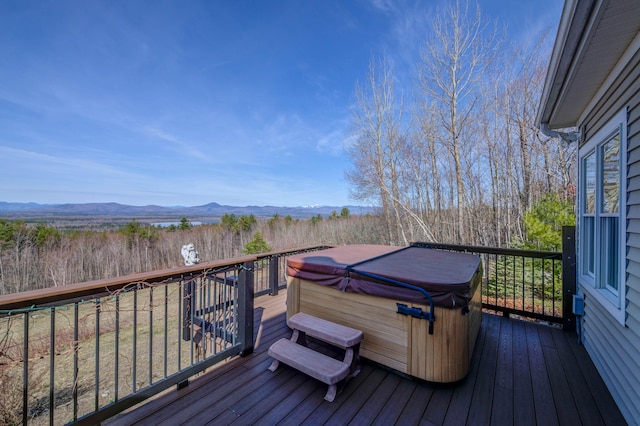 wooden deck with a hot tub and a mountain view