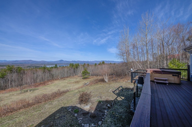 view of yard with a deck with mountain view and a hot tub