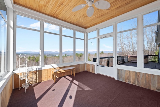 unfurnished sunroom featuring a mountain view and ceiling fan