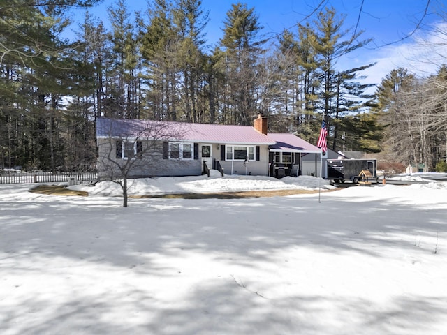 view of front facade with a chimney and metal roof