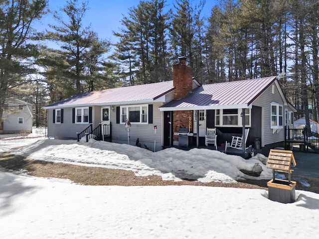 view of front of home featuring a chimney and metal roof