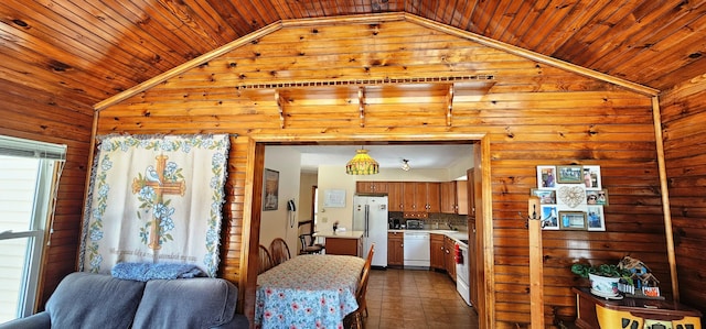 kitchen featuring lofted ceiling, wood walls, light countertops, wooden ceiling, and white appliances