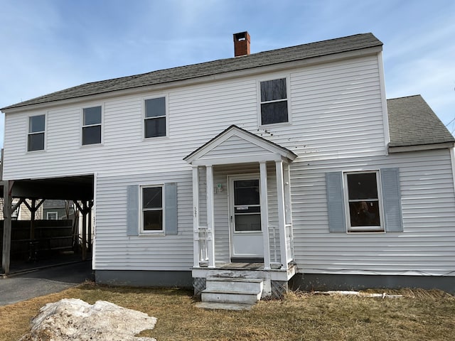 view of front of house featuring a chimney and roof with shingles