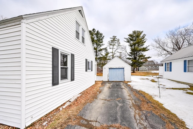 view of property exterior featuring an outbuilding, driveway, and a detached garage